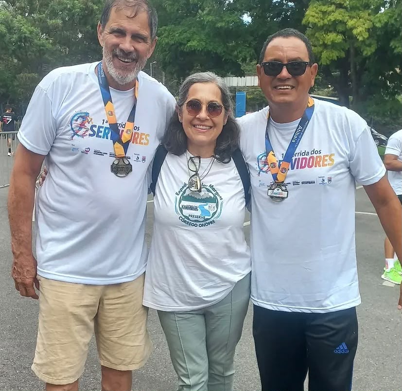 Trio de participantes com medalhas da corrida