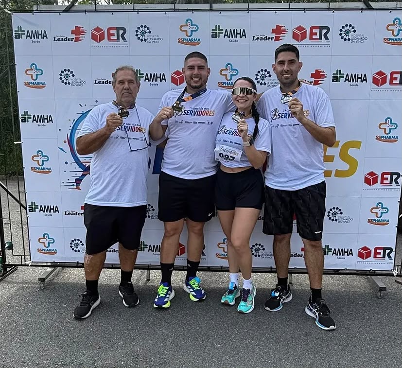 Atletas exibindo suas medalhas no painel de patrocinadores