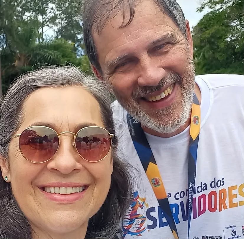 Casal de servidores sorrindo com a camiseta oficial do evento